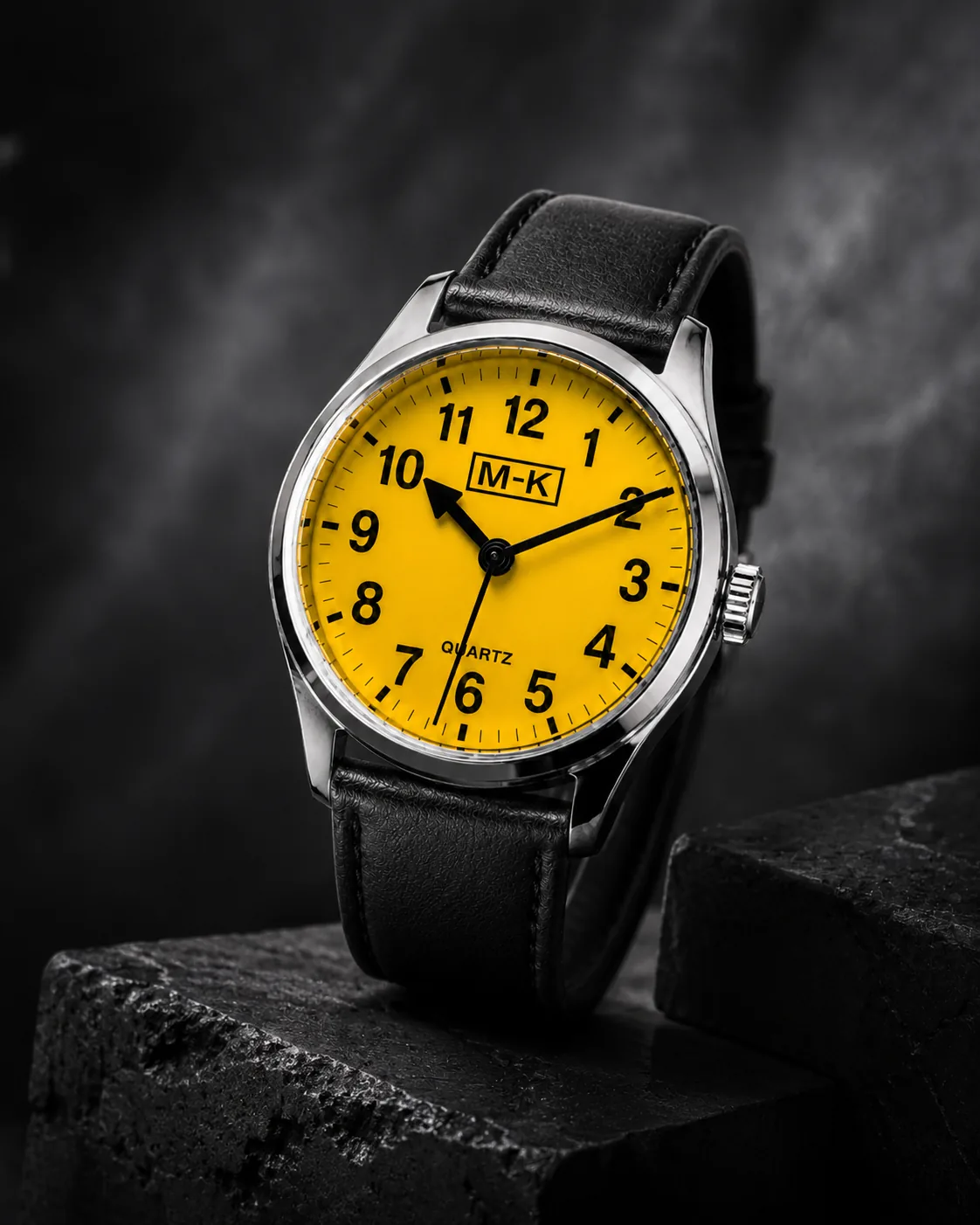 Yellow dial M-K watch photographed on dark stone